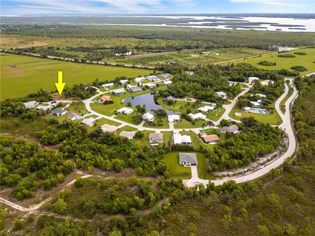 Aerial view of property's location with a large body of water and nearby suburban area