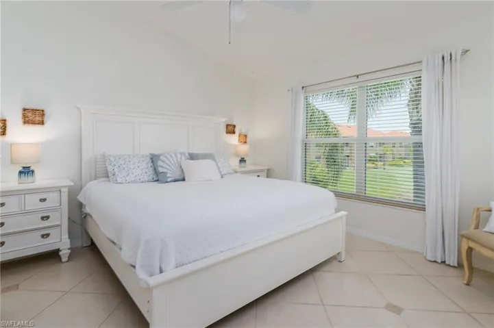 Bedroom with light tile patterned flooring, lofted ceiling, and a ceiling fan