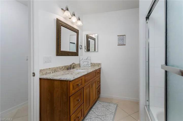 Bathroom featuring vanity, tile patterned floors, and shower / washtub combination