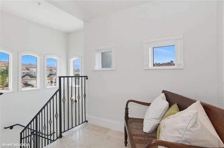 Sitting room with baseboards and an upstairs landing