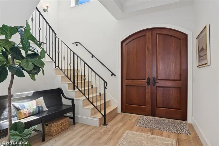 Foyer with stairway, wood finished floors, and baseboards