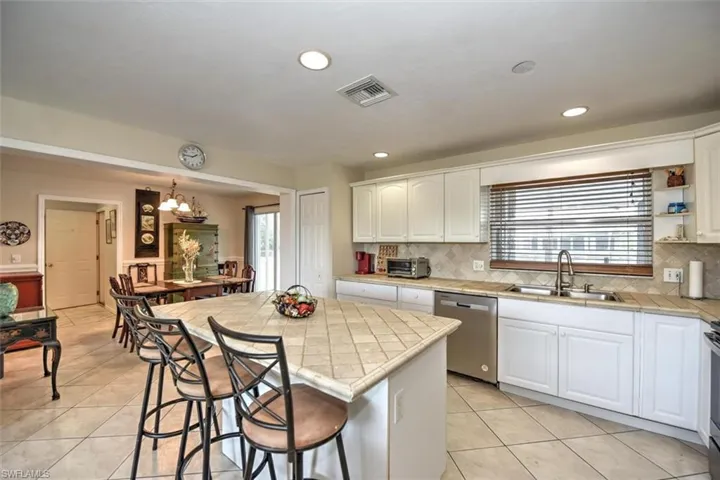 Kitchen with stainless steel dishwasher, a sink, visible vents, and a healthy amount of sunlight
