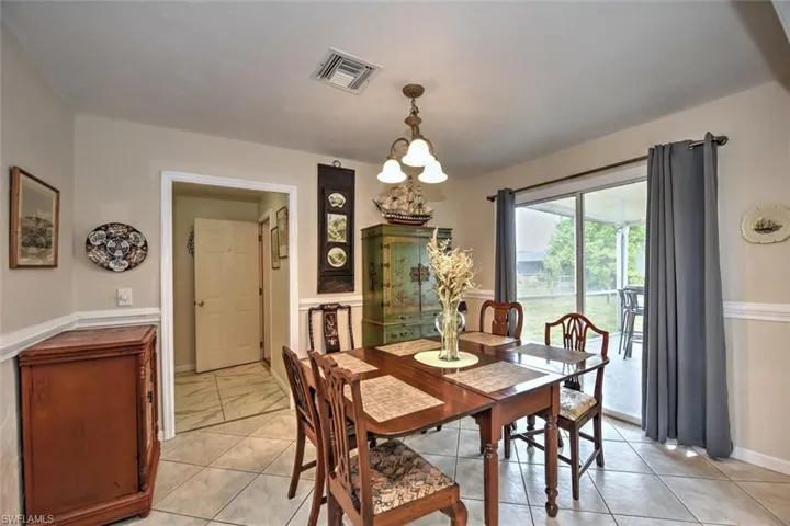 Dining room with a chandelier, baseboards, and visible vents