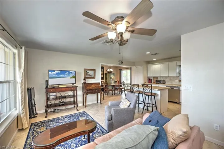 Living room featuring visible vents, a ceiling fan, and light tile patterned flooring