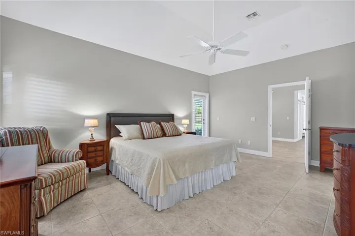 Bedroom with light tile patterned floors and ceiling fan