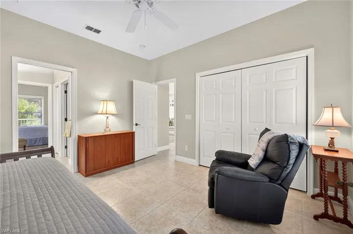 Living area with light tile patterned flooring and ceiling fan