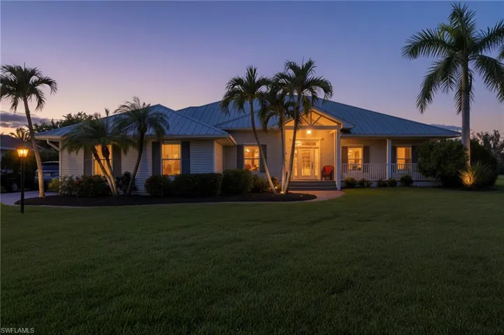 View of front of house featuring a metal roof, a front lawn, and covered porch