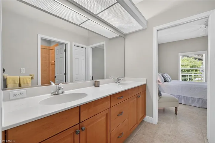 Ensuite bathroom featuring double vanity and light tile patterned floors