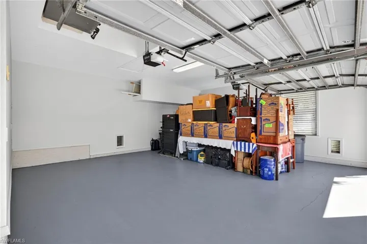 Garage featuring baseboards and a garage door opener