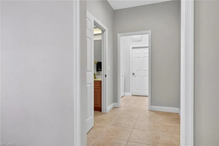 Corridor featuring light tile patterned floors and baseboards