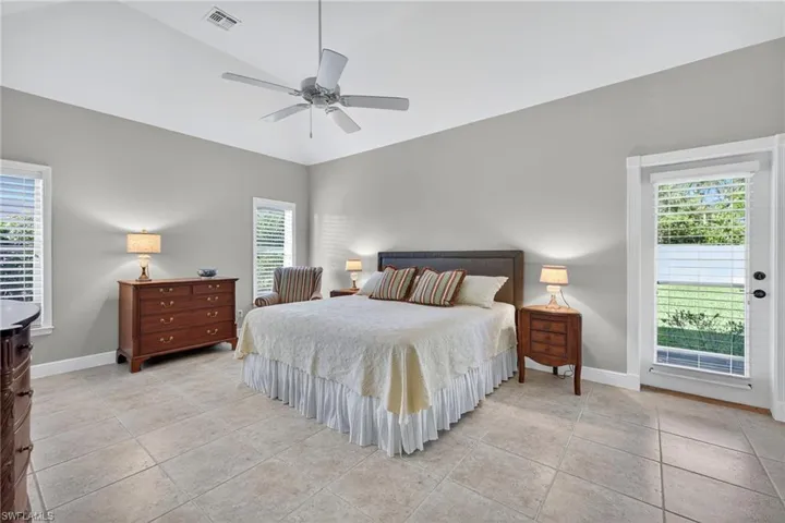 Bedroom with light tile patterned floors, a ceiling fan, lofted ceiling, and access to outside