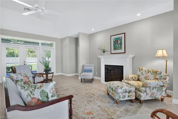Living room featuring light tile patterned flooring, a glass covered fireplace, recessed lighting, ceiling fan, and french doors