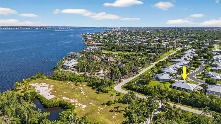 Aerial view of property and surrounding area with a large body of water and nearby suburban area