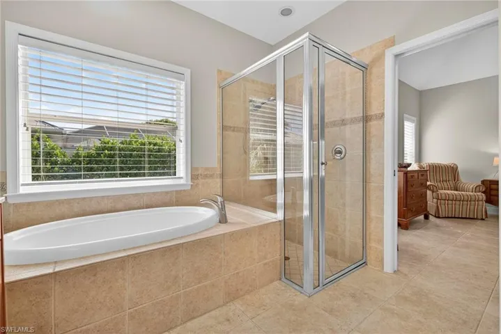 Full bath featuring tile patterned flooring, a garden tub, and a stall shower