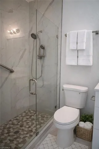Bathroom with a marble finish shower and vanity