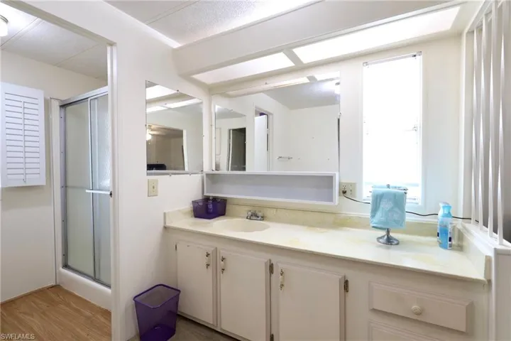 Bathroom featuring a shower with shower door, vanity, and hardwood / wood-style flooring