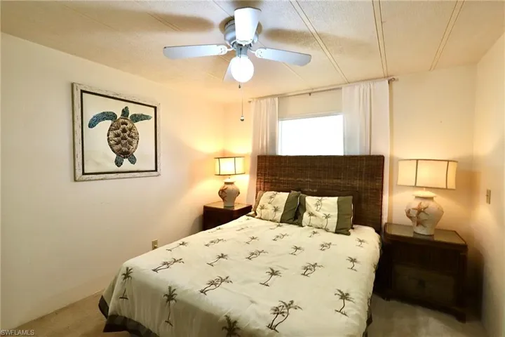 Bedroom featuring ceiling fan, a textured ceiling, and carpet flooring