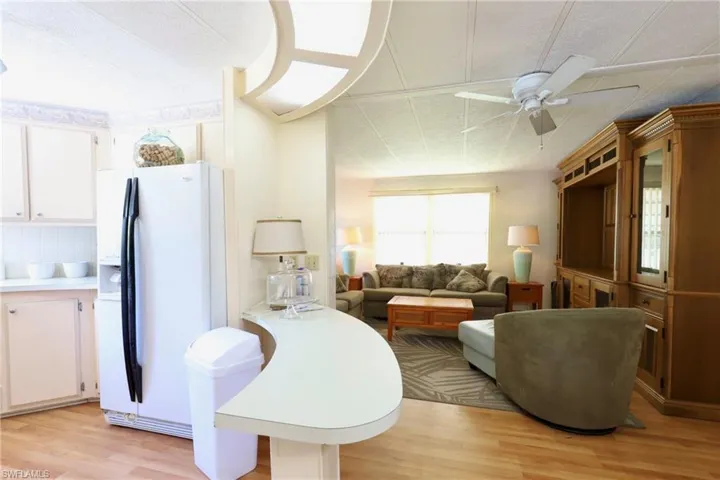 Living room with ceiling fan and light hardwood / wood-style flooring