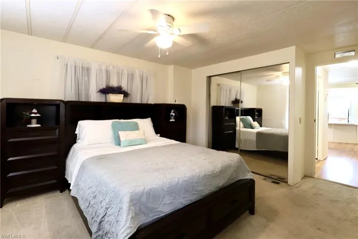 Carpeted bedroom with a closet and ceiling fan