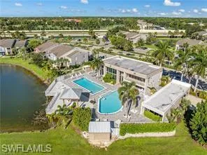 Drone / aerial view of a pool area and a nearby body of water