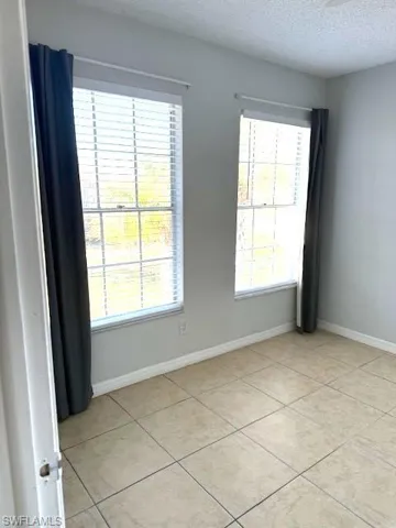 Unfurnished room featuring a textured ceiling and light tile patterned floors