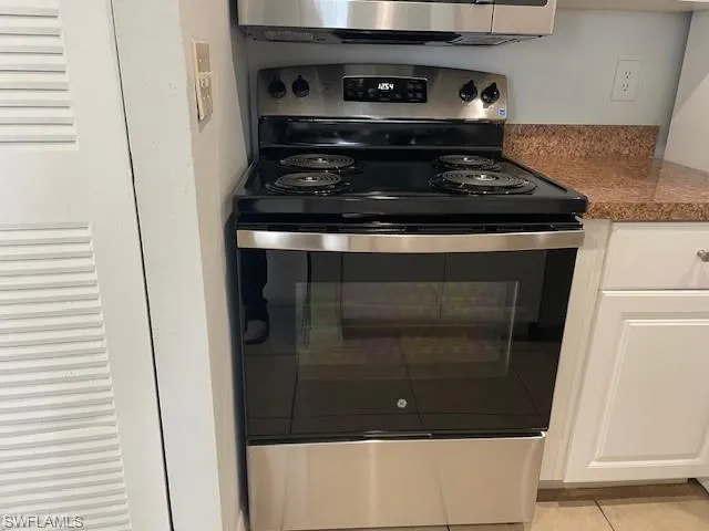 Kitchen view of stainless steel appliances and white cabinets