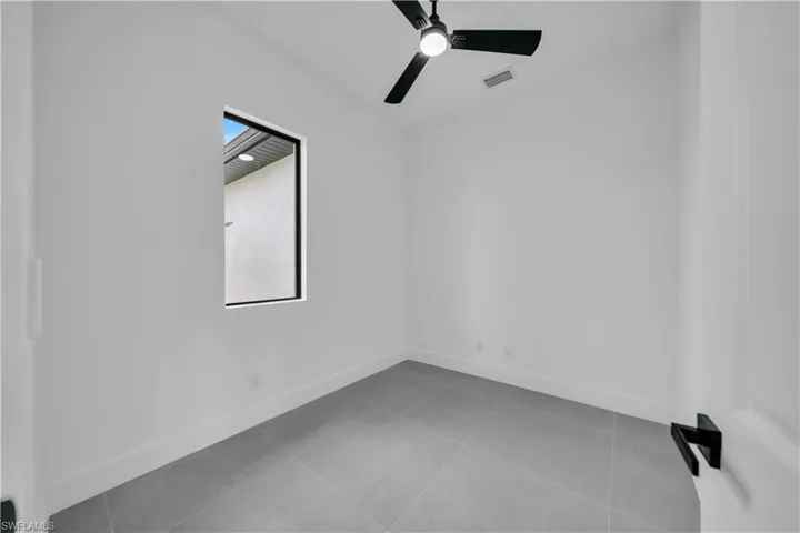 Unfurnished room featuring a ceiling fan and tile patterned flooring