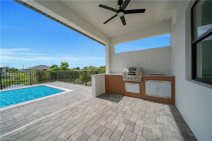 View of patio with area for grilling and a ceiling fan