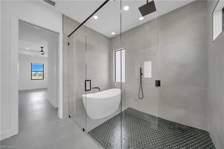 Full bathroom with a stall shower, a soaking tub, a ceiling fan, and recessed lighting