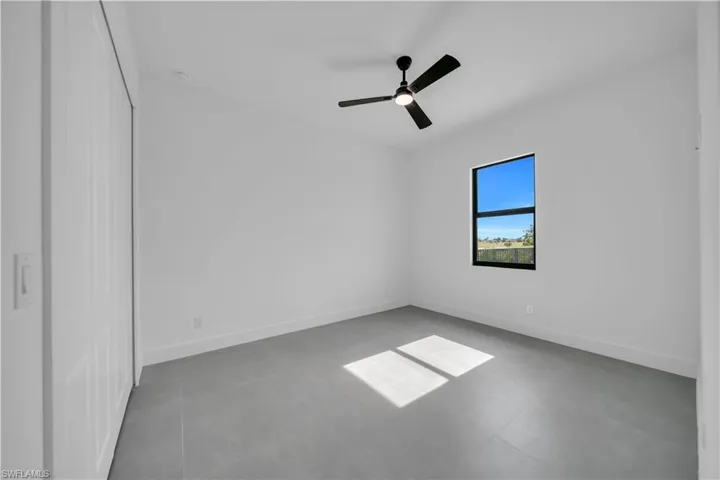 Empty room featuring baseboards and a ceiling fan