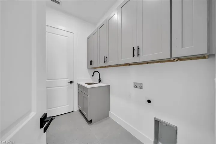 Washroom with washer hookup, cabinet space, and hookup for an electric dryer