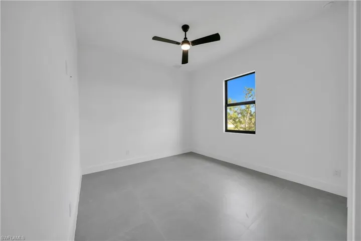 Empty room featuring baseboards and ceiling fan