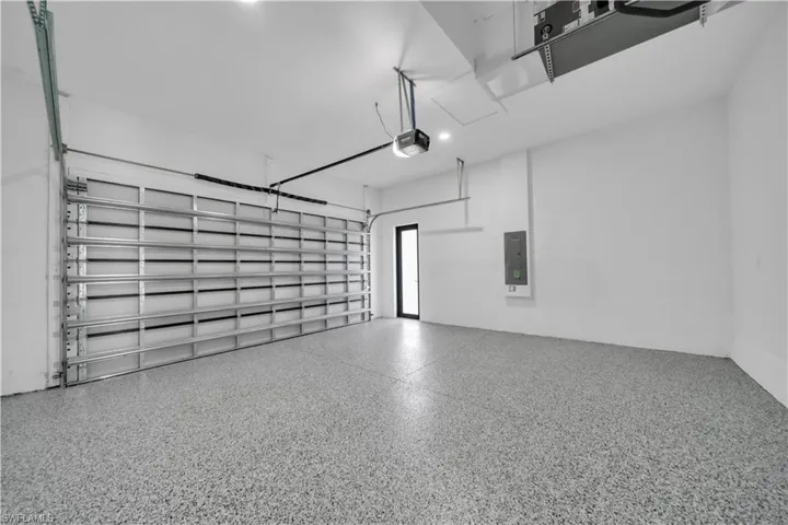 Garage featuring electric panel and a garage door opener