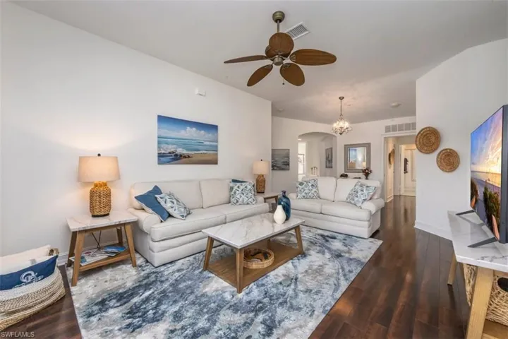 Living area with arched walkways, beautiful wood flooring and a separation between the master suite and the guest rooms.
