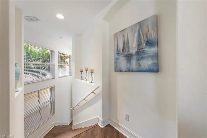 Stairs featuring wood finished floors and recessed lighting with bathed in light as you enter your oasis.