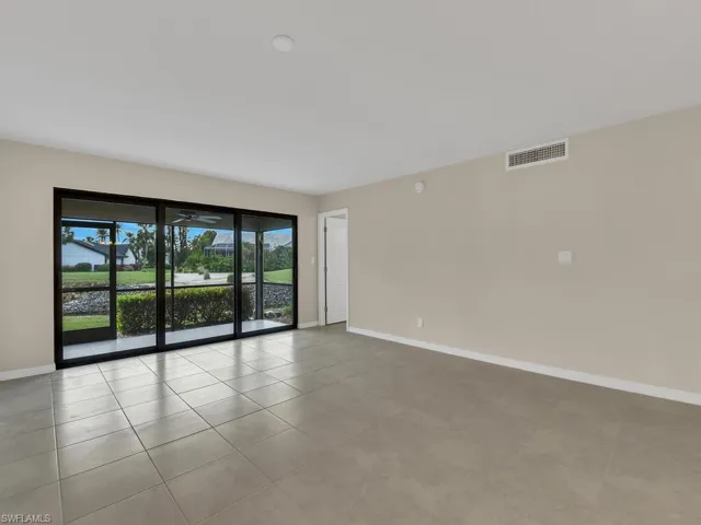 Tiled empty room featuring visible vents and baseboards
