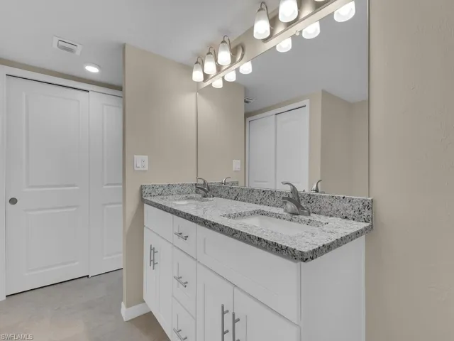 Full bathroom featuring double vanity, visible vents, a closet, and a sink
