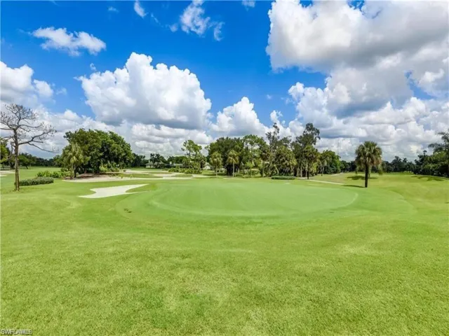 View of home's community with view of golf course and a yard