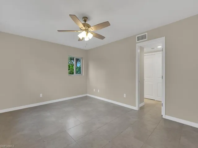 Empty room with visible vents, baseboards, and ceiling fan