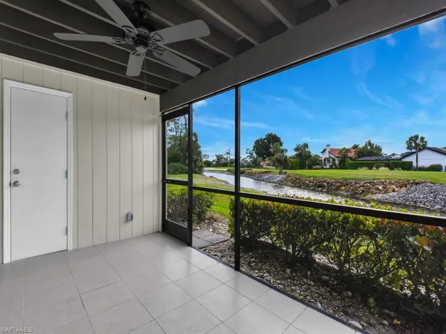Unfurnished sunroom with beam ceiling, a ceiling fan, and a water view
