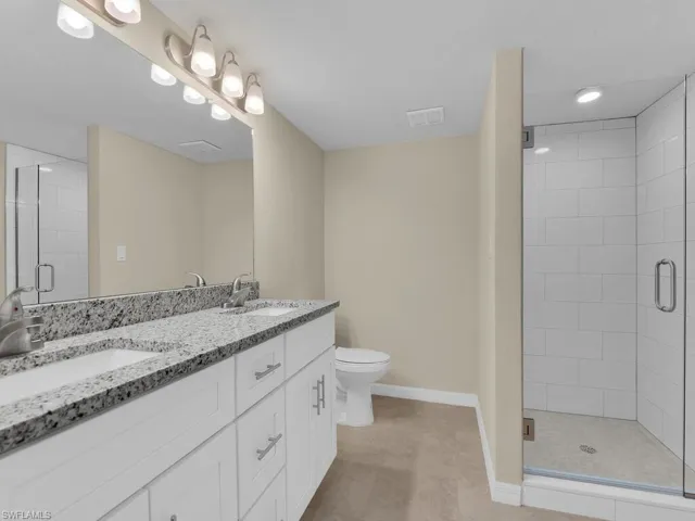 Full bath featuring a sink, visible vents, and a shower stall