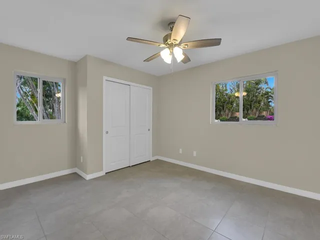 Unfurnished bedroom featuring a ceiling fan, baseboards, and a closet