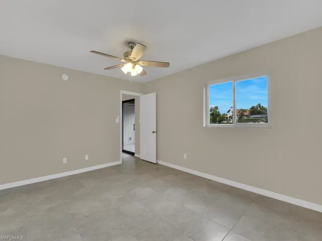 Empty room with baseboards and ceiling fan