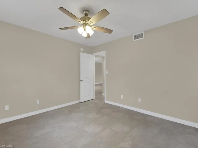 Spare room featuring a ceiling fan, visible vents, and baseboards
