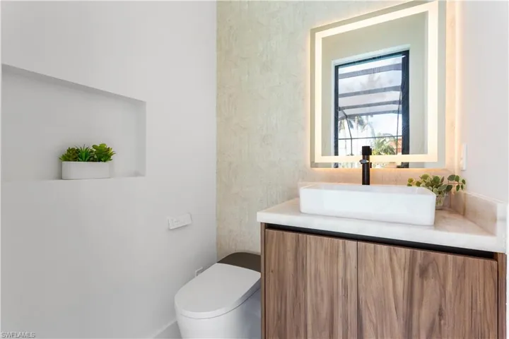 Pool Bathroom (Half Bath) with electric toilet, lighted mirror, and vessel sink