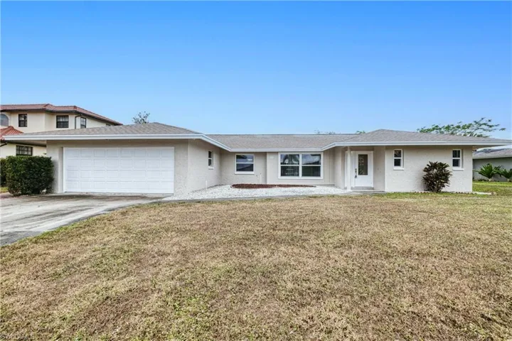 View of front of house featuring a front yard and a garage