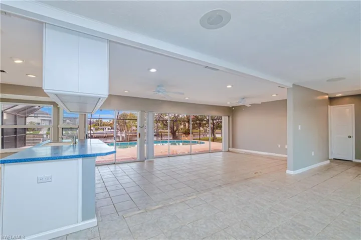 dining area overlooks kitchen and great room with pool/canal views