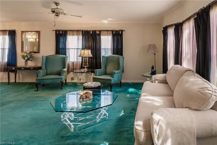 Living room with a wealth of natural light, carpet flooring, and ceiling fan
