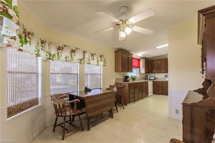 Kitchen with sink, ceiling fan, white dishwasher, and ornamental molding