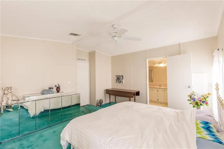 Bedroom featuring lofted ceiling, a closet, crown molding, a textured ceiling, and ceiling fan